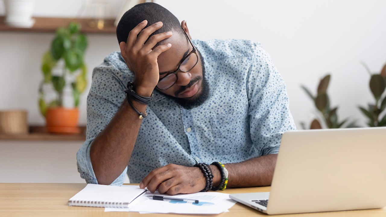 stressed man sitting in front of his laptop